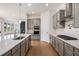 A bright kitchen with gray cabinetry, stainless steel appliances, and a large white island with seating at 7785 Wild Violet Dr, Cumming, GA 30040