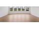 Bright living room featuring hardwood floors and large windows with views of the neighborhood at 7785 Wild Violet Dr, Cumming, GA 30040