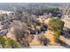 An aerial view shows a cozy, single-story home nestled among mature trees and lush landscaping at 105 Ruff Harris Dr, Dallas, GA 30157