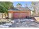 A detached brick garage with two bays and matching maroon doors at 105 Ruff Harris Dr, Dallas, GA 30157