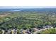 Aerial view of a neighborhood with upscale homes surrounded by lush, mature trees, with a lake in the background at 302 Grant Ct, Canton, GA 30114