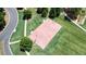 Overhead view of a well-maintained basketball court with neatly trimmed grass, bordered by trees and sidewalks at 302 Grant Ct, Canton, GA 30114