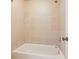 Close up of tiled shower and white tub in this bathroom with a beige color palette at 302 Grant Ct, Canton, GA 30114