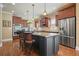 Open concept kitchen features a center island, stainless appliances, granite counters, and pendant lighting at 302 Grant Ct, Canton, GA 30114