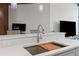 Close-up of a kitchen sink with a cutting board, stylish faucet, and white countertop at 400 W West Peachtree Nw St, Atlanta, GA 30308