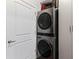 Laundry room with stackable washer and dryer and white cabinet at 400 W West Peachtree Nw St, Atlanta, GA 30308