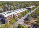 Aerial view showcases a multi-story brick apartment complex near tree-lined streets and parking at 1291 Briarwood Ne Rd, Brookhaven, GA 30319