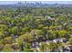 An aerial view shows homes surrounded by dense trees against the backdrop of a distant city at 1291 Briarwood Ne Rd, Brookhaven, GA 30319
