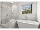 Luxurious bathroom with a soaking tub, walk-in shower, and marble tile at 1291 Briarwood Ne Rd, Brookhaven, GA 30319