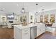 An open kitchen and living room layout, an island with seating, stainless appliances and hardwood floors at 1291 Briarwood Ne Rd, Brookhaven, GA 30319