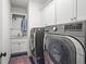 Laundry room featuring front load washer and dryer, tiled floors, and sink at 1291 Briarwood Ne Rd, Brookhaven, GA 30319