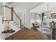 Open living area featuring hardwood floors, white wainscoting, and a curated gallery wall leading to the staircase at 1291 Briarwood Ne Rd, Brookhaven, GA 30319