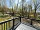 Open wooden deck showing a verdant wooded backyard with mature trees and a house in the distance at 2919 Manitoba Ln, Marietta, GA 30062