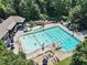 Aerial view of a community pool with multiple swimming areas, lounge chairs, and lush landscaping at 555 E Wesley Ne Rd, Atlanta, GA 30305