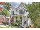 Charming two-story white brick home with a welcoming front porch, landscaped yard and an American flag at 555 E Wesley Ne Rd, Atlanta, GA 30305