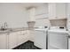 This laundry room features lots of cabinets, a sink, and modern, front loading washer and dryer at 555 E Wesley Ne Rd, Atlanta, GA 30305