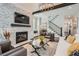 Bright living room featuring a stone fireplace, modern decor, and open staircase at 555 E Wesley Ne Rd, Atlanta, GA 30305