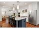 Open kitchen featuring stainless steel appliances, white cabinets, marble island with seating, and hardwood floors at 1450 N Morningside Ne Dr, Atlanta, GA 30306