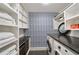 Bright laundry room features blue patterned wallpaper, granite countertops, and white cabinets with ample storage space at 1450 N Morningside Ne Dr, Atlanta, GA 30306