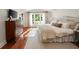 Bright main bedroom with hardwood floors showcases a dresser and large window, offering ample natural light at 1450 N Morningside Ne Dr, Atlanta, GA 30306