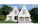 Charming, white brick home featuring unique roof peaks, modern garage doors, and a professionally landscaped yard at 1872 Georgian Terrace, Brookhaven, GA 30341