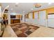 A large basement area offers tiled flooring, access to storage rooms, an entertainment area, and a refrigerator at 1920 Barrington Dr, Jonesboro, GA 30236
