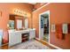 Bathroom featuring double sinks, an oversized mirror, a walk-in closet, and warm lighting at 1920 Barrington Dr, Jonesboro, GA 30236