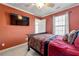 This bedroom features an elegant bed with a dark wood frame, TV and an exit door to the outside at 1920 Barrington Dr, Jonesboro, GA 30236