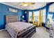 A stylish bedroom boasts bright blue walls, bay windows with yellow drapes, and a wooden bed frame at 1920 Barrington Dr, Jonesboro, GA 30236