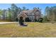Well-manicured front lawn showcasing the two-story brick house, enhanced by shaped bushes and verdant trees at 1920 Barrington Dr, Jonesboro, GA 30236