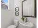 Half bathroom with pedestal sink, framed mirror, and natural light at 59 Tallulah Trl, Sharpsburg, GA 30277