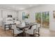 Open dining area with modern table and chairs, sliding doors to the back deck, and white cabinets at 59 Tallulah Trl, Sharpsburg, GA 30277
