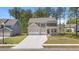 Two-story home with stone accents, three-car garage, long driveway and manicured lawn at 59 Tallulah Trl, Sharpsburg, GA 30277