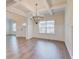 Elegant dining area with coffered ceilings, wainscoting, and a modern chandelier for a sophisticated ambiance at 806 Relic Rdg, Hampton, GA 30228