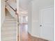Inviting entryway with staircase and hardwood floors leading to a bright living area with coffered ceilings and modern chandelier at 806 Relic Rdg, Hampton, GA 30228