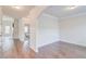 Hallway with archway showcasing hardwood floors, white trim, and access to bedroom at 806 Relic Rdg, Hampton, GA 30228