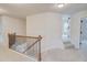 Upstairs hallway features neutral carpet, decorative railing and views into secondary bedrooms at 806 Relic Rdg, Hampton, GA 30228