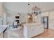 Open concept kitchen with stainless steel appliances, white cabinets and center island overlooks the staircase and living area at 806 Relic Rdg, Hampton, GA 30228