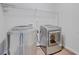 Laundry room with modern washer and dryer, wire rack shelving and hardwood floors at 806 Relic Rdg, Hampton, GA 30228