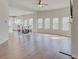 Bright living room with hardwood floors, many windows, and an open floorplan leads into a modern kitchen at 806 Relic Rdg, Hampton, GA 30228