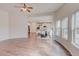 Open concept living room features hardwood floors, many windows and adjoins a kitchen with island and white cabinets at 806 Relic Rdg, Hampton, GA 30228