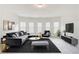 Modern living room with bay window, plush seating and sleek decor, perfect for entertaining and relaxing at 806 Relic Rdg, Hampton, GA 30228