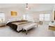 Bright main bedroom featuring a large bed, bench, and chair at 806 Relic Rdg, Hampton, GA 30228