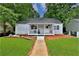 Charming single story home with a cozy front porch, green lawn and a walkway to the front door at 1094 Regent Sw St, Atlanta, GA 30310