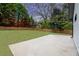 Large backyard with a concrete patio, privacy fence, and mature trees, ideal for outdoor activities at 1934 Pinedale Pl, Decatur, GA 30032