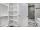 Walk-in closet that leads into a bathroom with a modern walk-in shower and white vanity at 1934 Pinedale Pl, Decatur, GA 30032