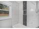 Modern bathroom features a white tub with tiled walls and a contrasting black and white accent stripe at 1934 Pinedale Pl, Decatur, GA 30032