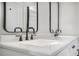 Bathroom vanity featuring white countertops, dual sinks, modern fixtures, and black framed mirrors at 1934 Pinedale Pl, Decatur, GA 30032