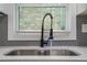Modern kitchen sink with black faucet and a window view, complemented by a white countertop at 1934 Pinedale Pl, Decatur, GA 30032