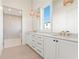 Bright bathroom featuring double vanity sinks with marble countertops and a glass-enclosed shower at 260 Guild Ln, Fayetteville, GA 30214